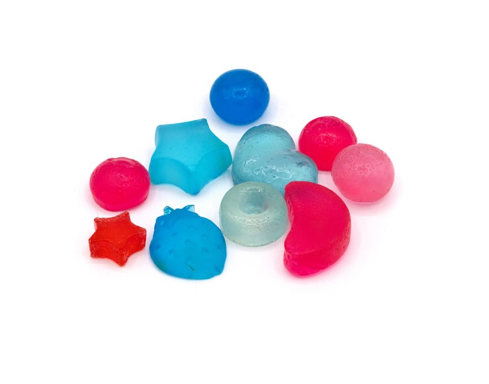A small cluster of translucent moulded beads in pink, red, blue, turquoise and pale green, shaped as stars, spheres, domes and berry forms.