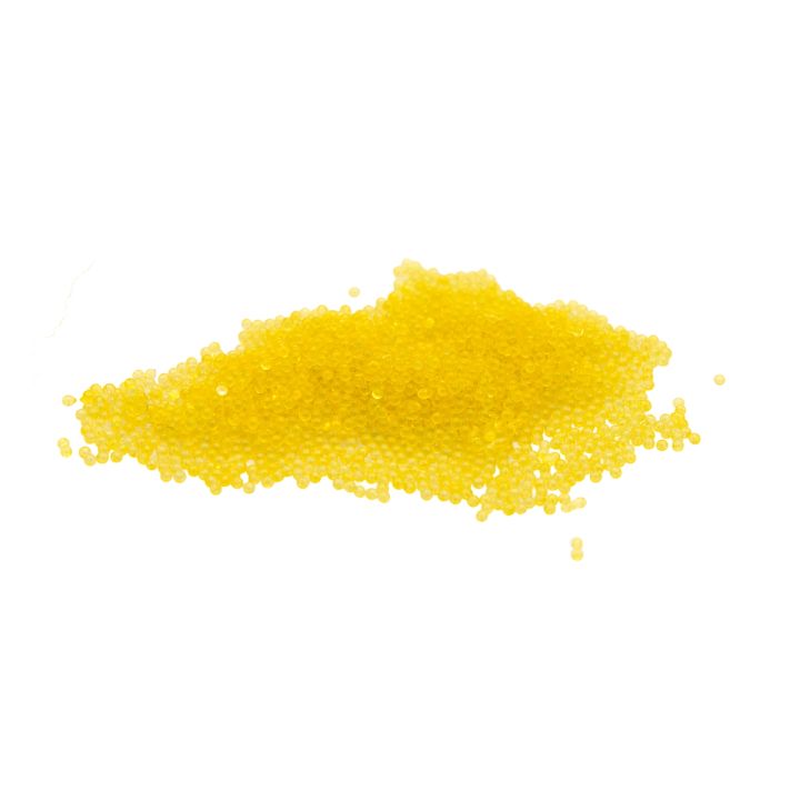 A heap of thermochromic pigment as tiny spherical beads in bright yellow, glossy and loosely piled.