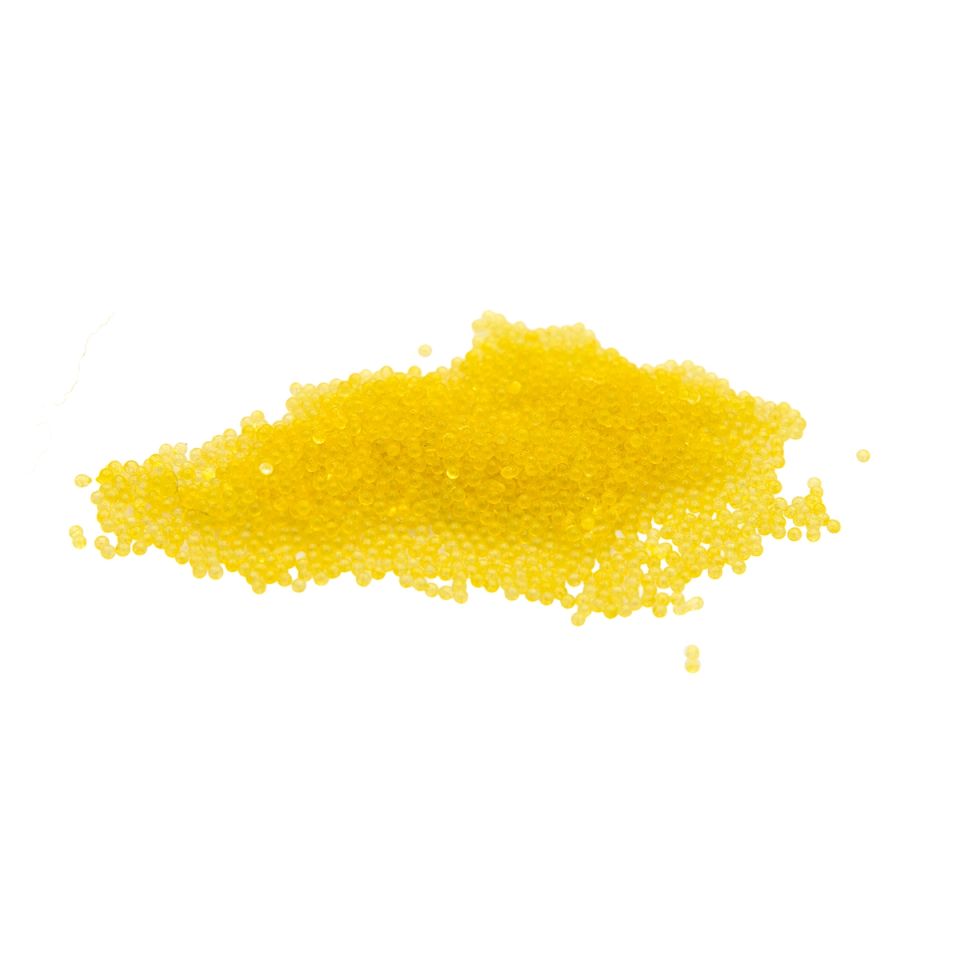 A heap of thermochromic pigment as tiny spherical beads in bright yellow, glossy and loosely piled.