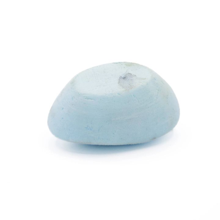 The same oval from the side, its domed profile and flat underside visible and the pale blue surface finely granular.