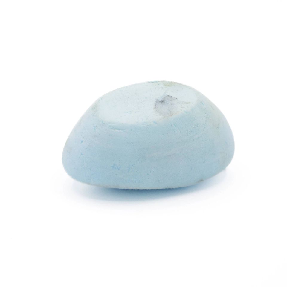The same oval from the side, its domed profile and flat underside visible and the pale blue surface finely granular.