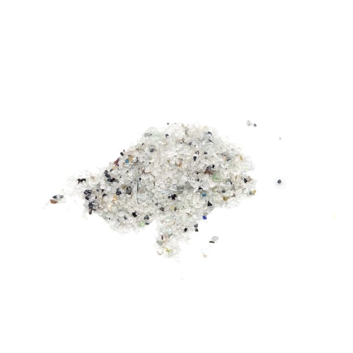 A smaller heap of the granules from above, the clear frosted chips shot through with black and iridescent specks.