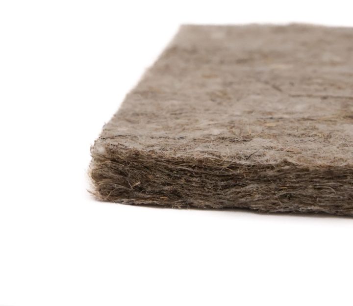 A close view of the pad's cut edge, showing how the matted hemp fibre is layered and compressed into a thick felt.