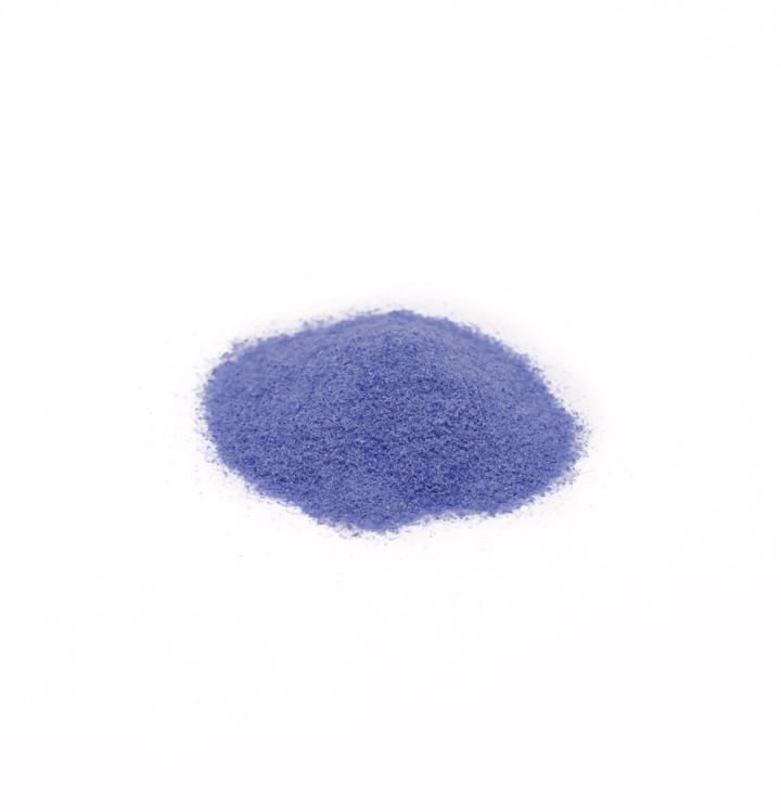 A neat mound of enamel powder in strong violet-blue, the grains fine and evenly sifted.
