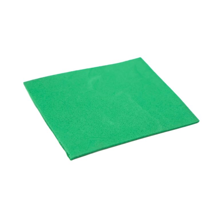 The green square at an angle, showing its flat matte face and thin even cross-section.