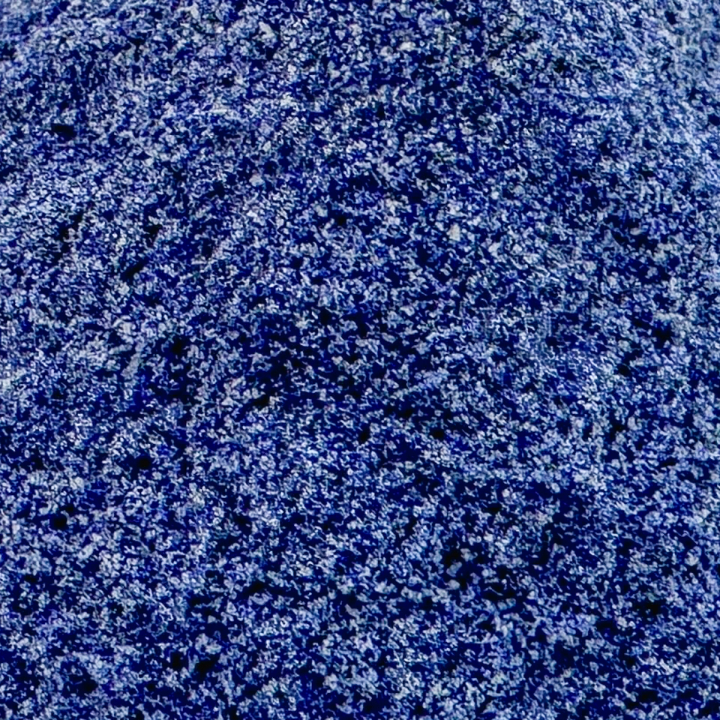 A close view of the powder filling the frame, its cobalt grains mottled with paler blue and white flecks.