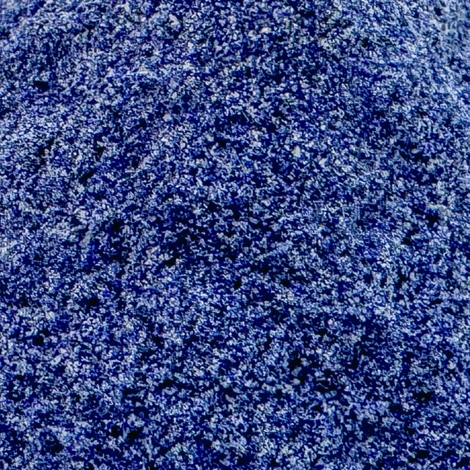 A close view of the powder filling the frame, its cobalt grains mottled with paler blue and white flecks.