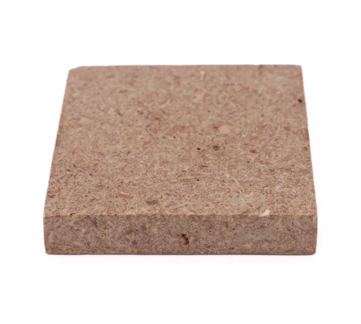 The whole tile at an angle, showing its full square face together with the depth of its edge.