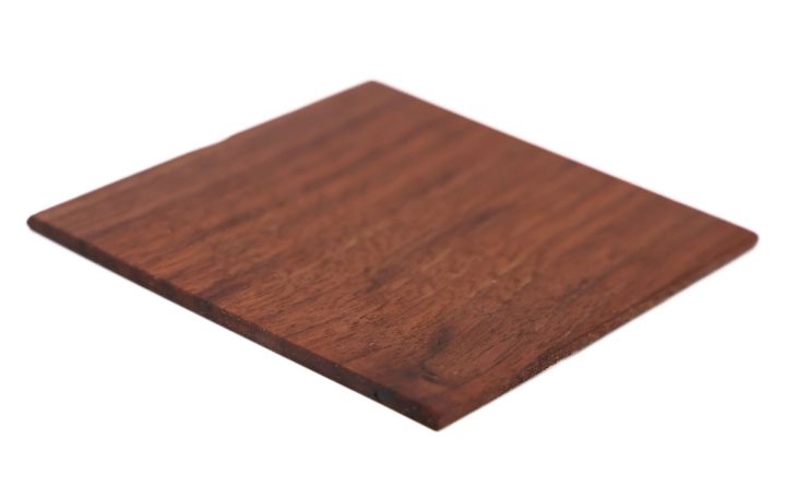 The same square tilted to catch the light, the grain reading glossier and warmer and the thinness of the sample visible along its edge.
