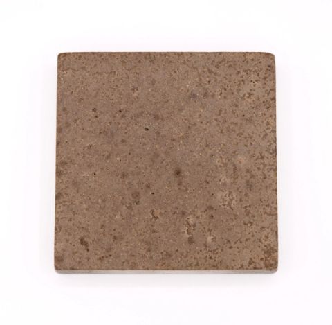 A square tile in muted grey-brown, its surface finely speckled with darker particles.