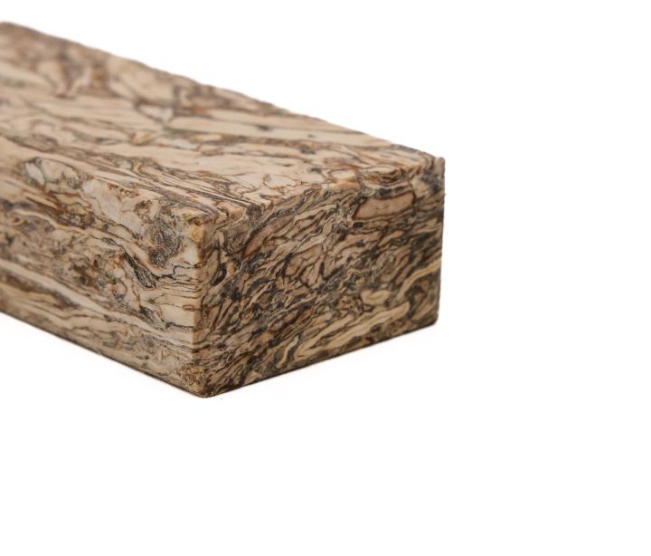 The block close from a corner, the swirling fibre pattern running continuously across the top and end faces.