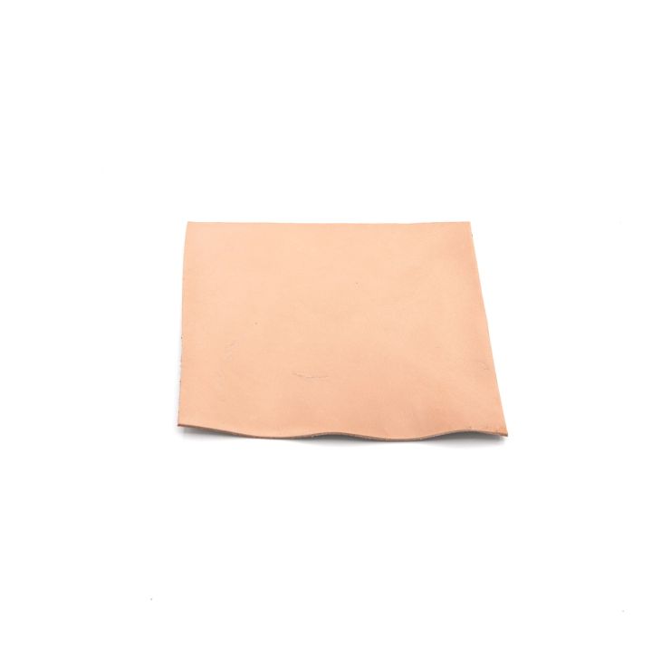 A square of chrome-tanned bison leather in soft blush pink, one corner lifting to show its suede-like reverse.