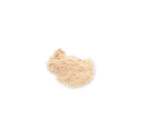 A small heap of fine, pale beige powder, the granules sugar-like and faintly glinting.