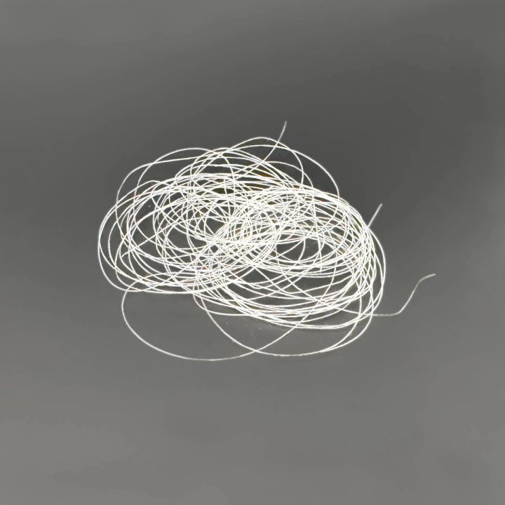The filament coil from further back, the loops looser with a single strand trailing away.