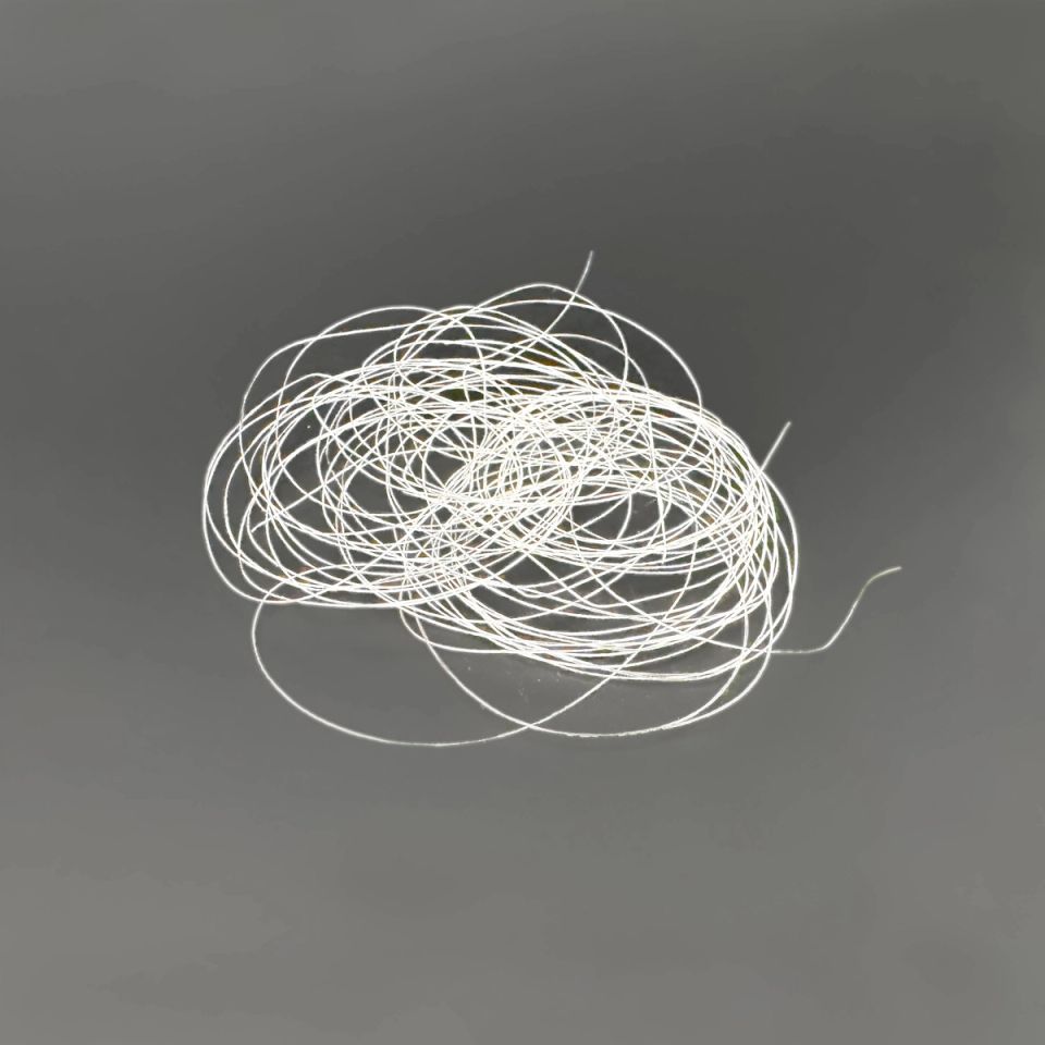 The filament coil from further back, the loops looser with a single strand trailing away.
