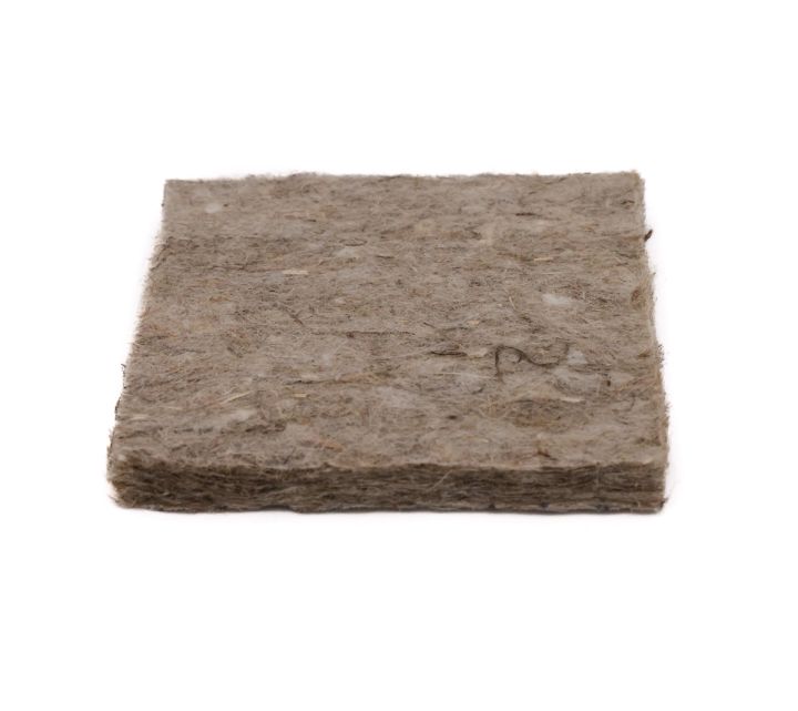 The pad at an angle from above, its greyish felted surface flecked with paler fibres and its edge softly compressed.