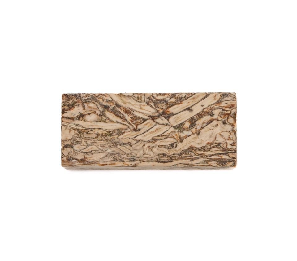 A rectangular block of engineered hemp lumber, its face a swirling marbled pattern of cream and dark brown running lengthwise.