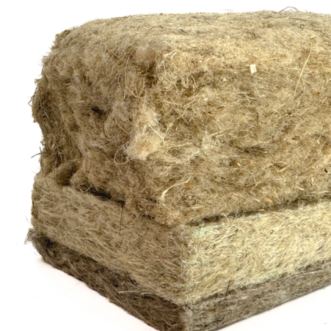 A dense rectangular block of compressed fibre in olive-tan, its surface bristling with fine hairs and pressed into two visible layers.