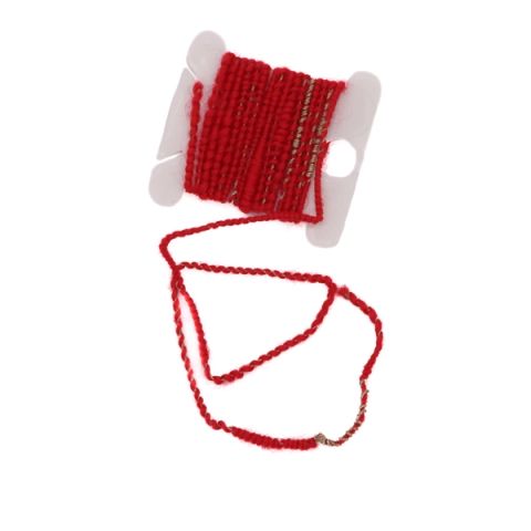 Bright red wool yarn wound on a white plastic bobbin with a loop trailing below; a fine metallic wire runs alongside the wool and surfaces as bare silver coil across one section.
