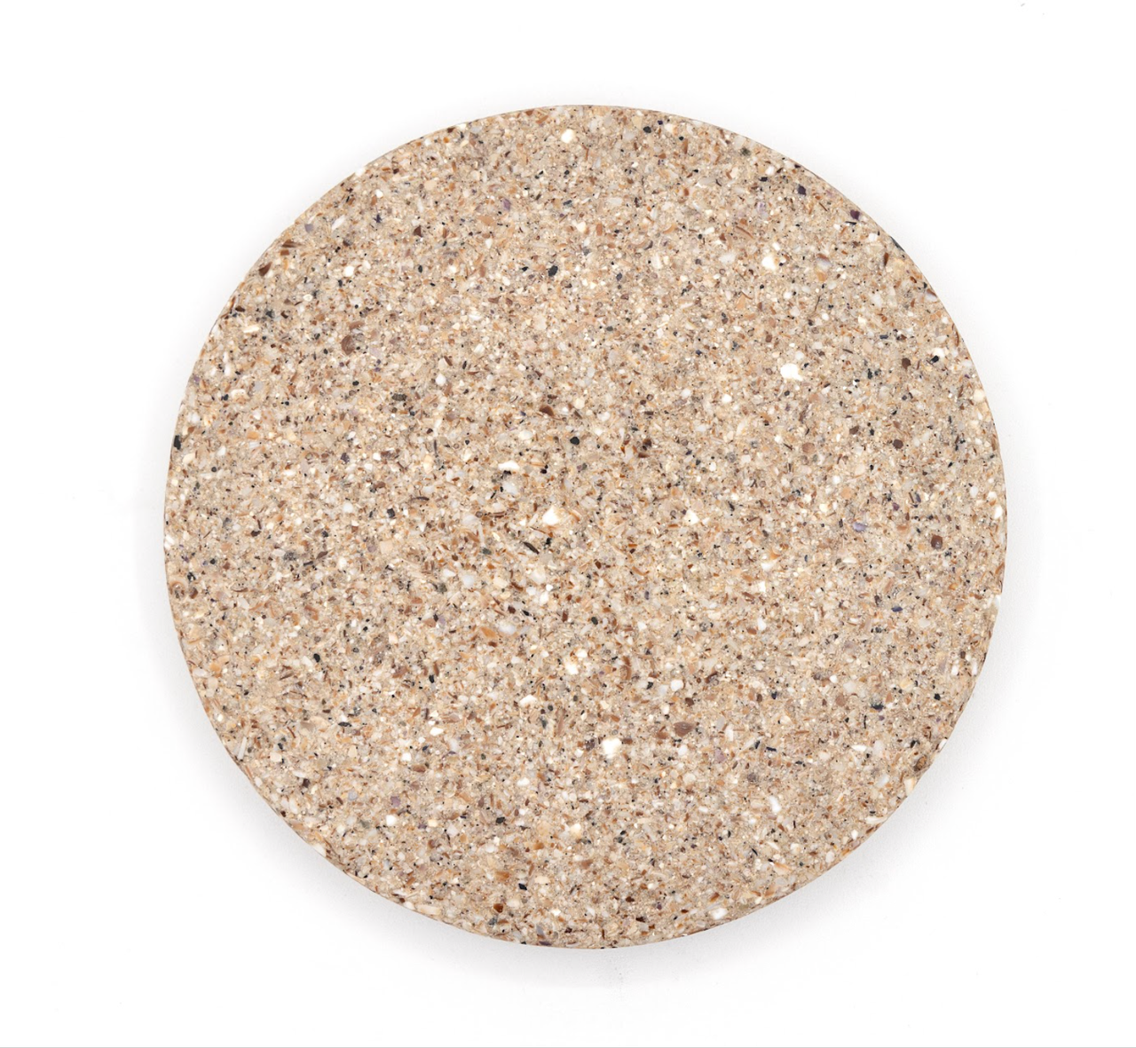 A larger round tile of dense composite in pale oatmeal, evenly speckled with fine crushed shell.