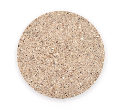 A larger round tile of dense composite in pale oatmeal, evenly speckled with fine crushed shell.