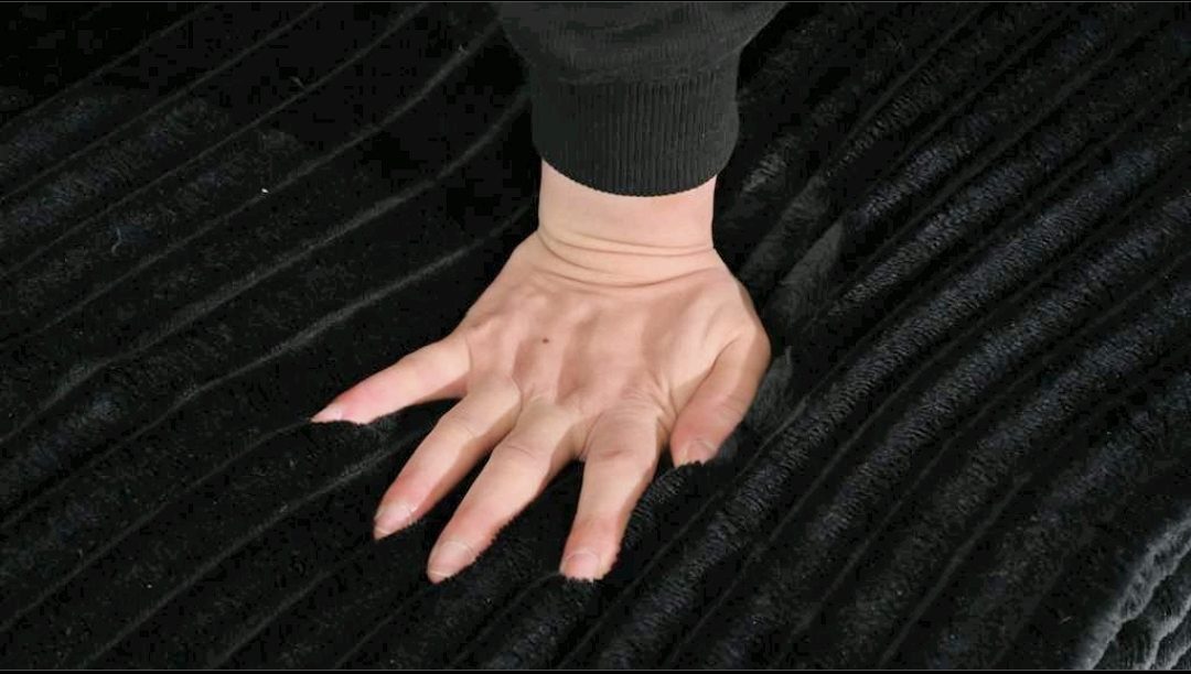 Hand pressing on wide-wale corduroy fabric texture