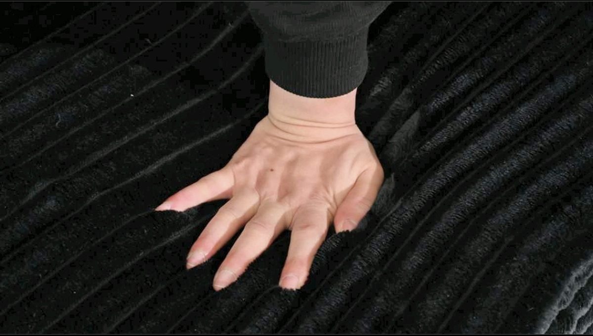 Hand pressing on wide-wale corduroy fabric texture