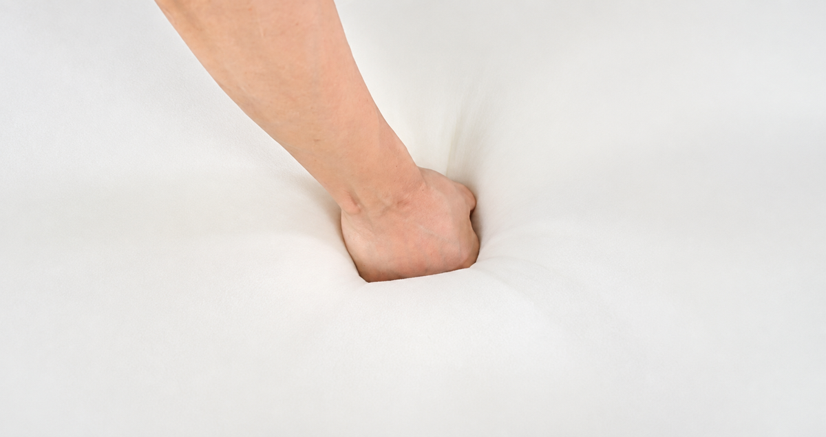 Fist pressing into high-resilience foam cushion