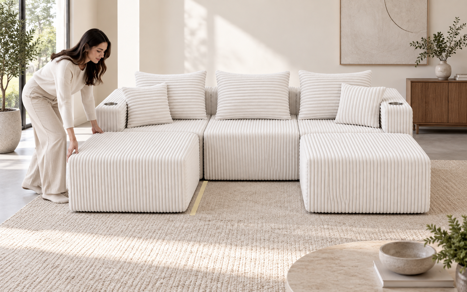 Woman aligning the left ottoman of a white Ultione THE BIG UX modular compressed sofa