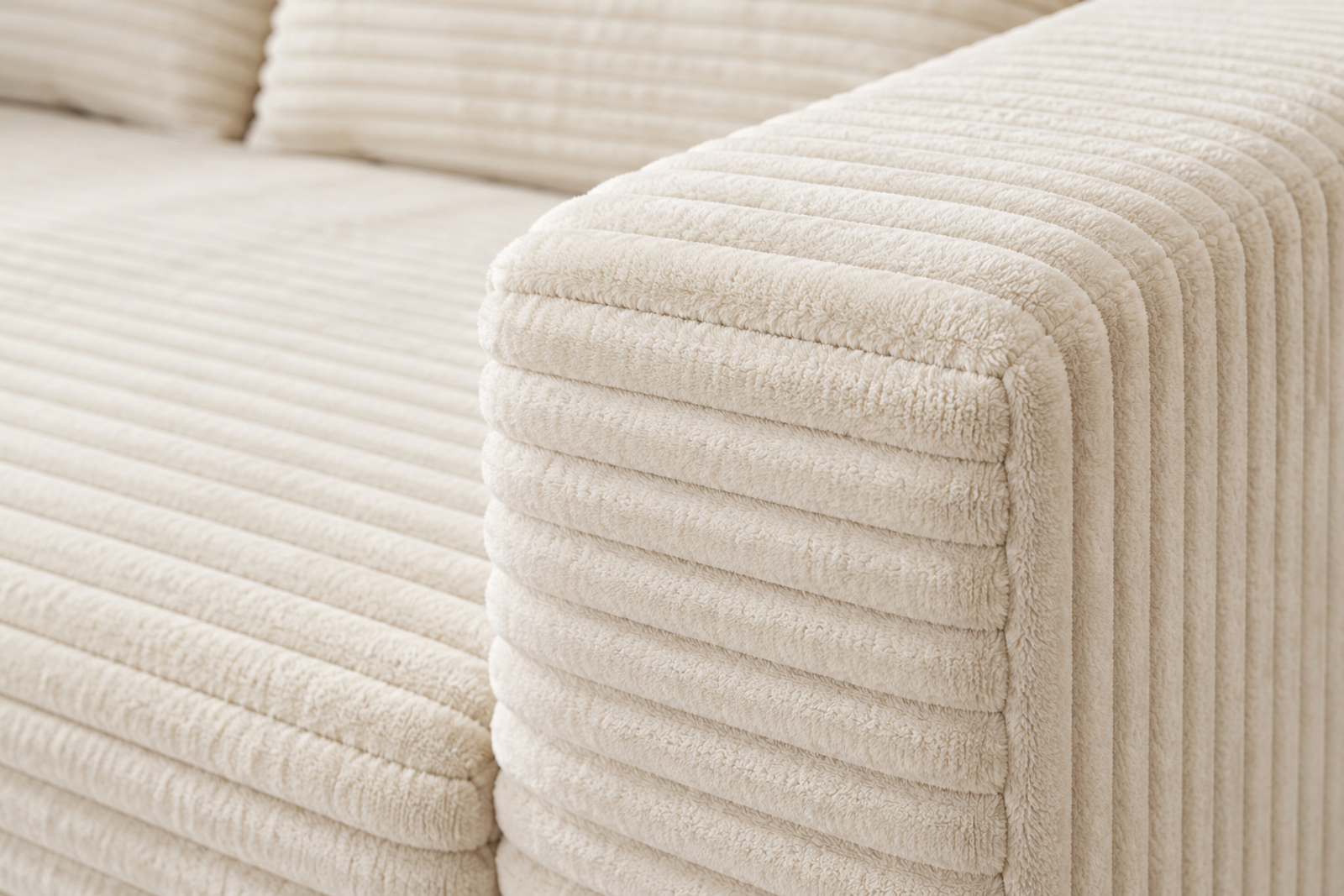 Close view of broad cream corduroy ribs and the joining seam on the softly squared ULTI ONE sofa arm.