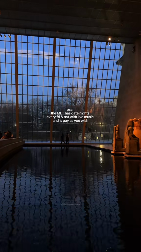The Temple of Dendur reflecting pool beside a tall glazed wall at dusk.