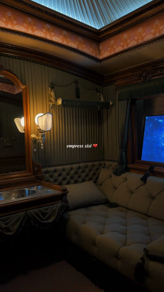 A tufted green compartment beneath a pale blue fabric ceiling.