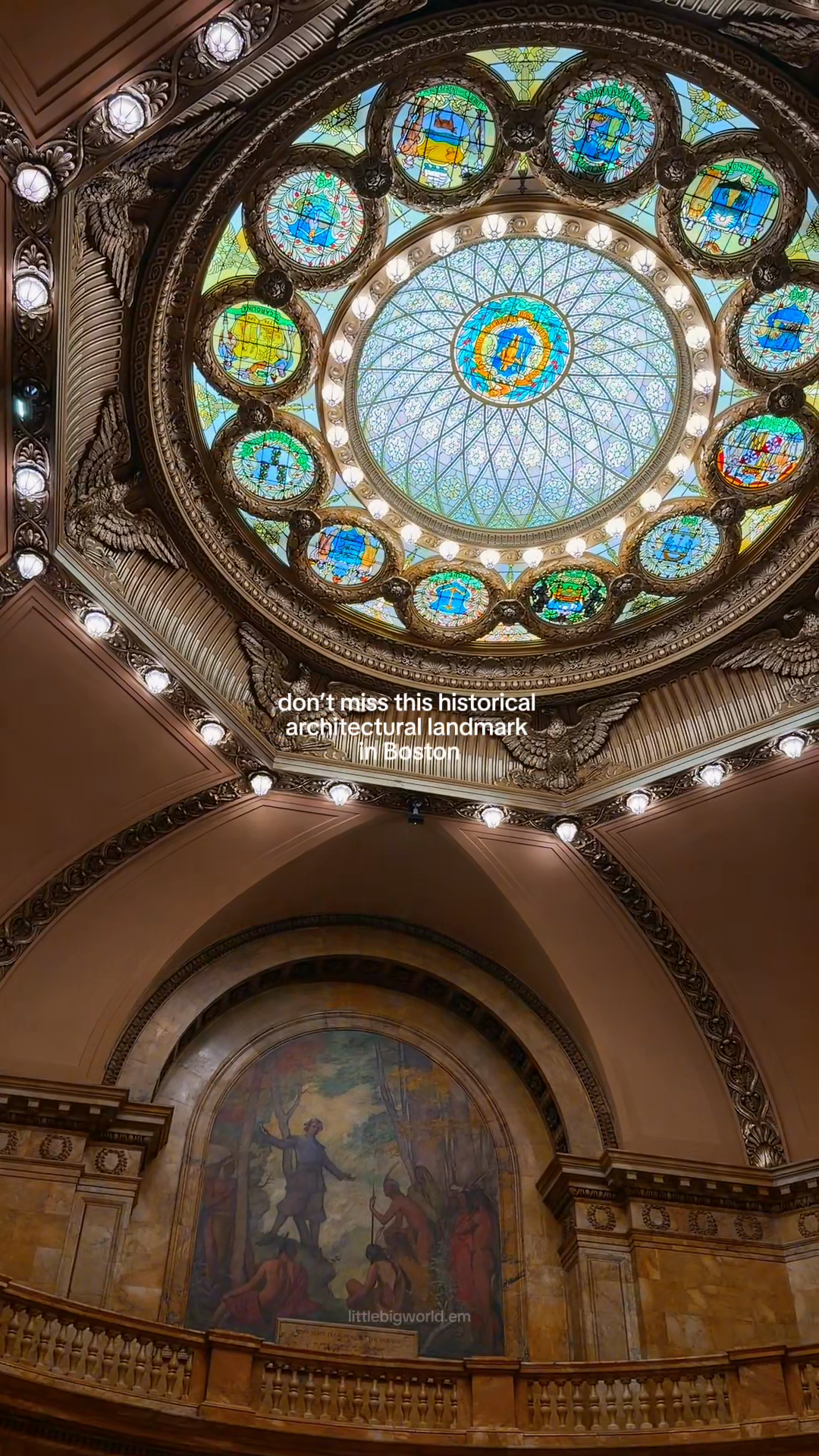 A round stained-glass skylight above an ornate hall in Boston.