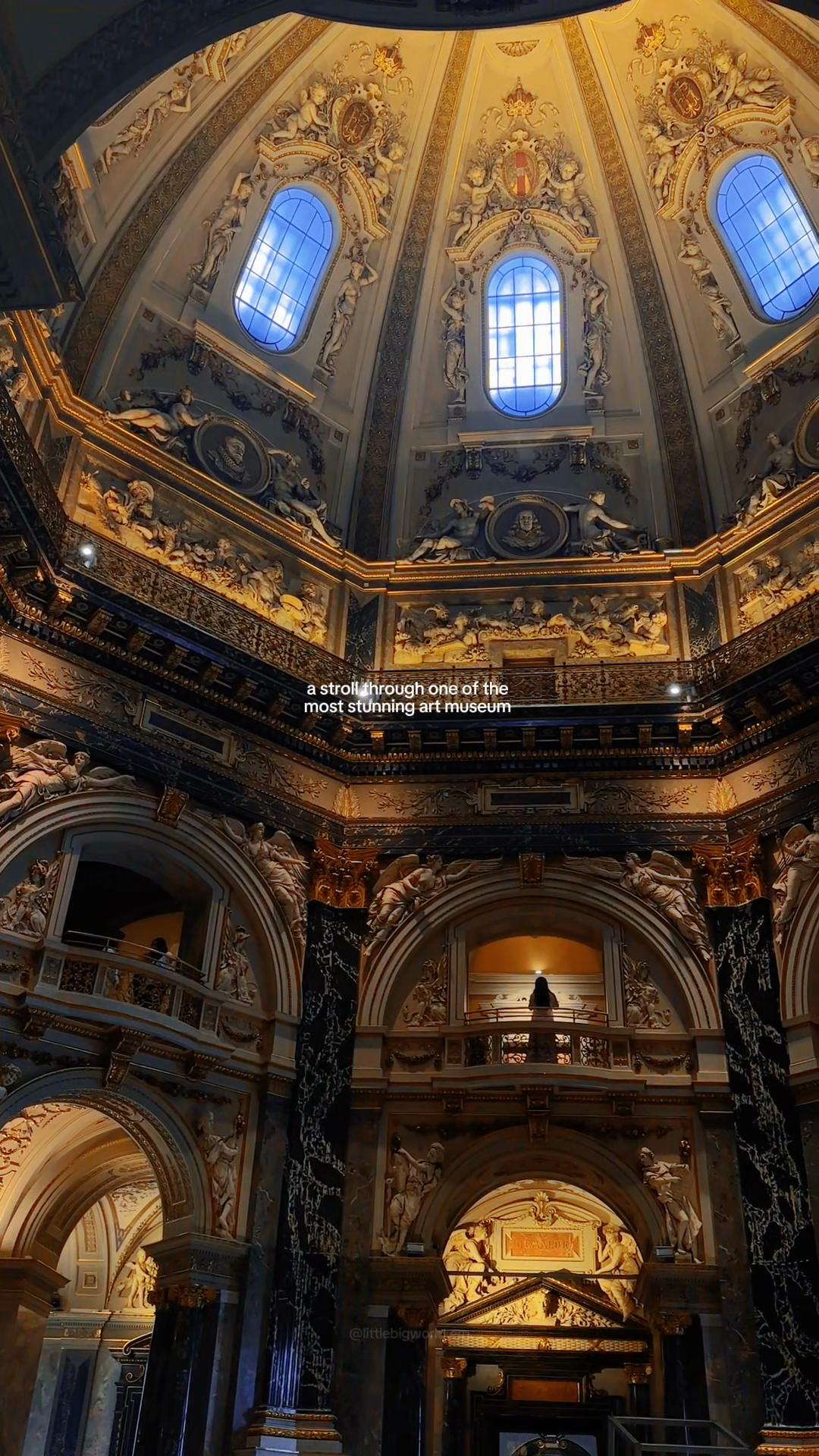 An elaborate domed museum hall with marble columns and gilded decoration.