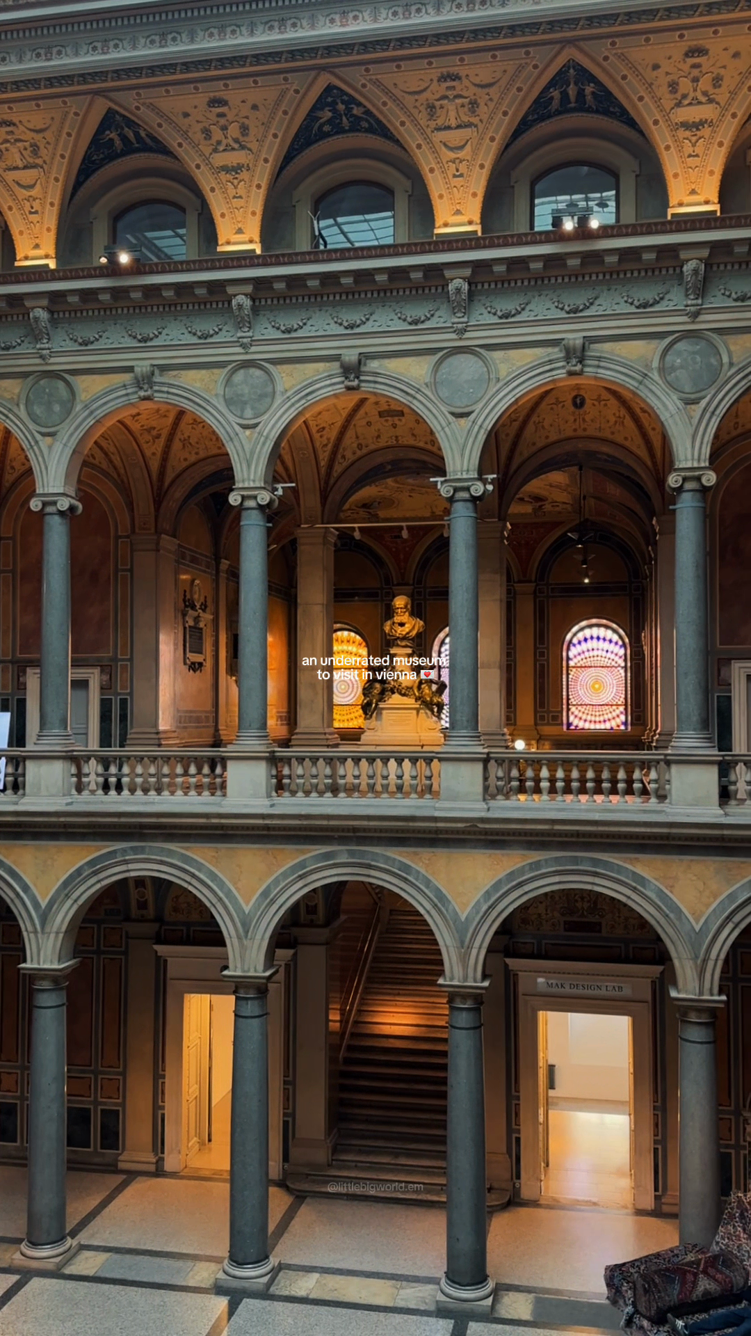 An ornate museum arcade with columns and painted pointed arches.