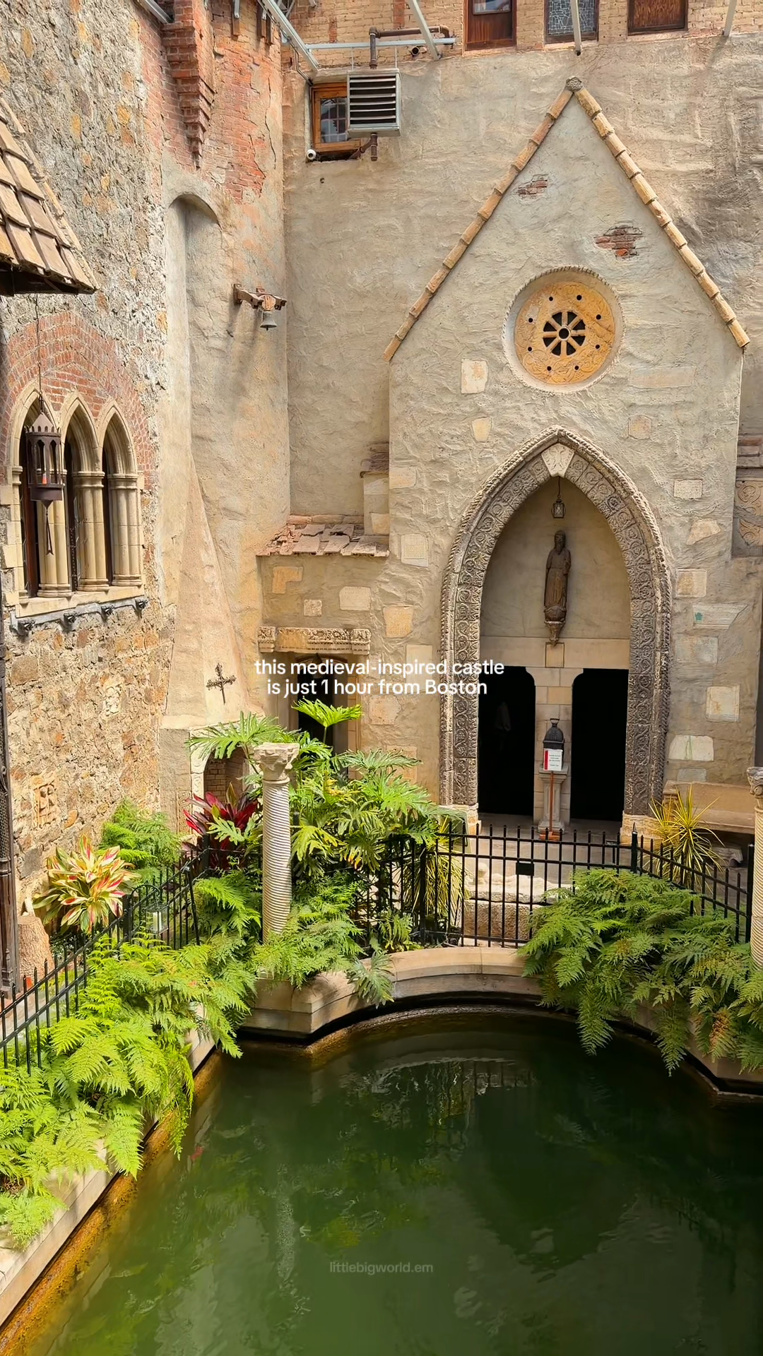 A stone courtyard with arched windows surrounds a green pool.