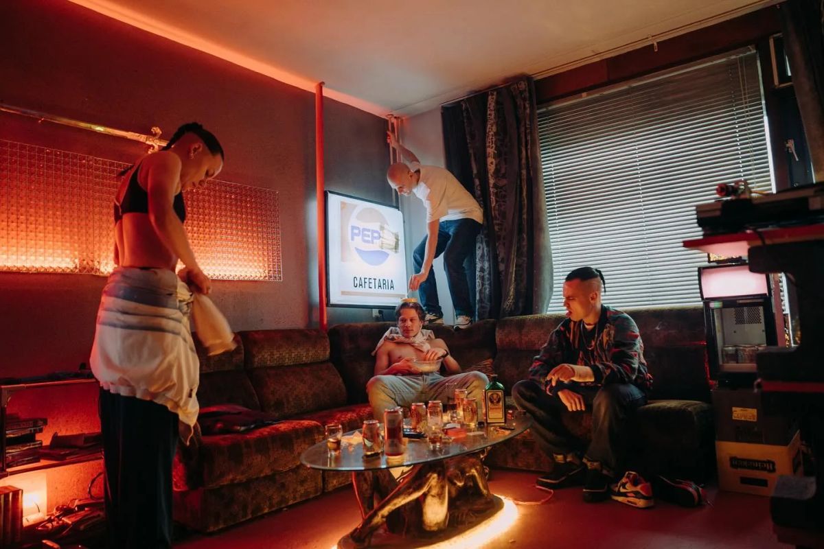 Cast and crew in a living-room set lit red.