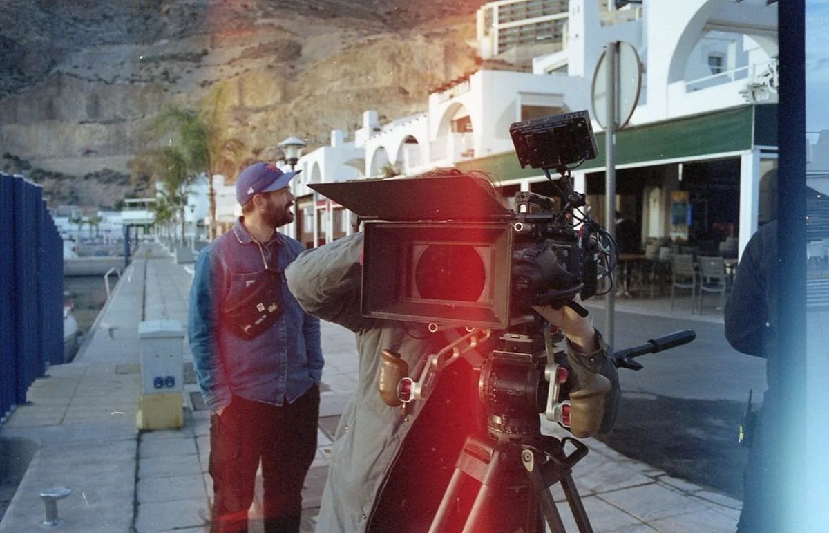 Analogue photo: a camera on a tripod on the quay, crew around it.