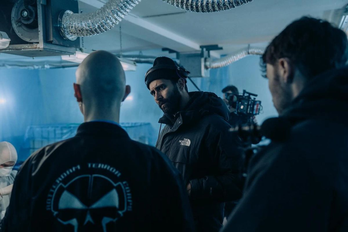 Crew and camera in a blue-lit set.