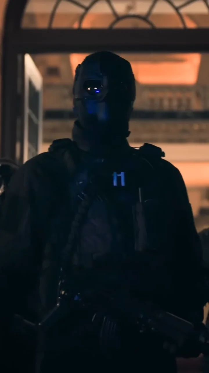 An armed man in a balaclava and tactical gear in a lobby.