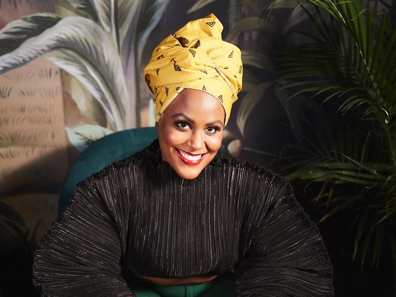 Tiffany-Anne Parkes smiling in front of a large fern.