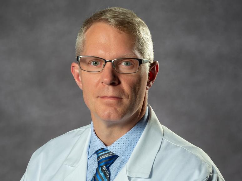 Dr. Evan R. Reiter on a gray background.