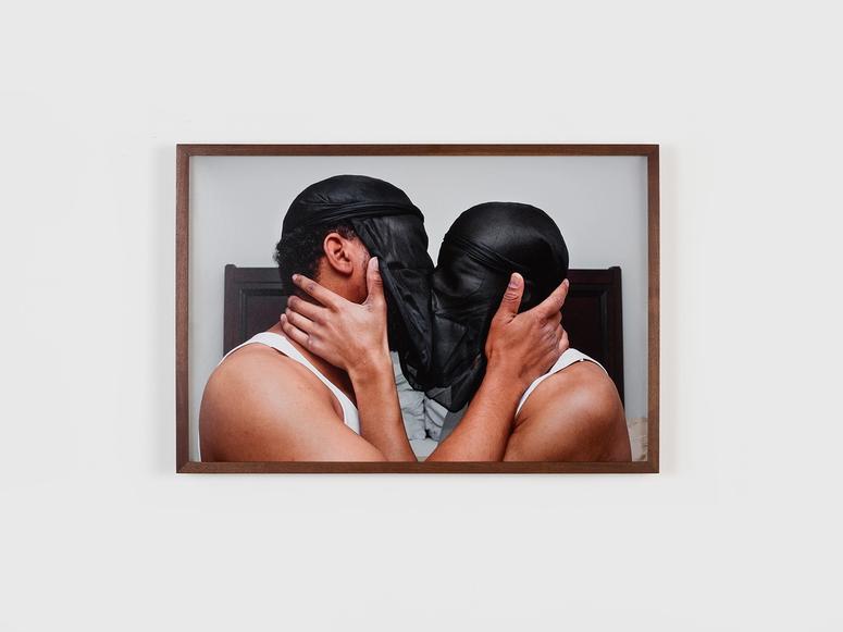 Two people kissing with black veils over their faces