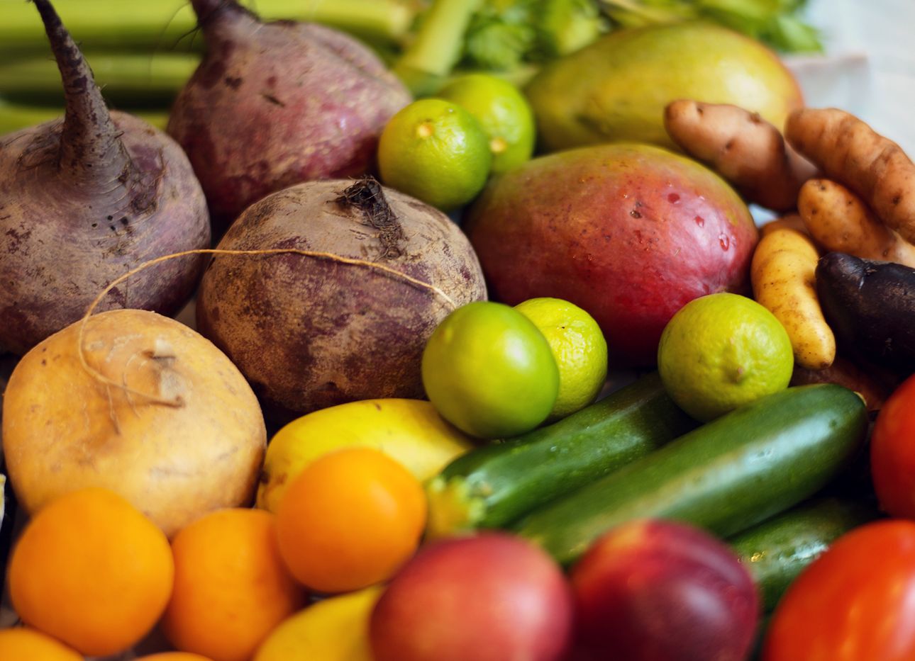 An assortment of brightly colored fruits and vegetables in close up.