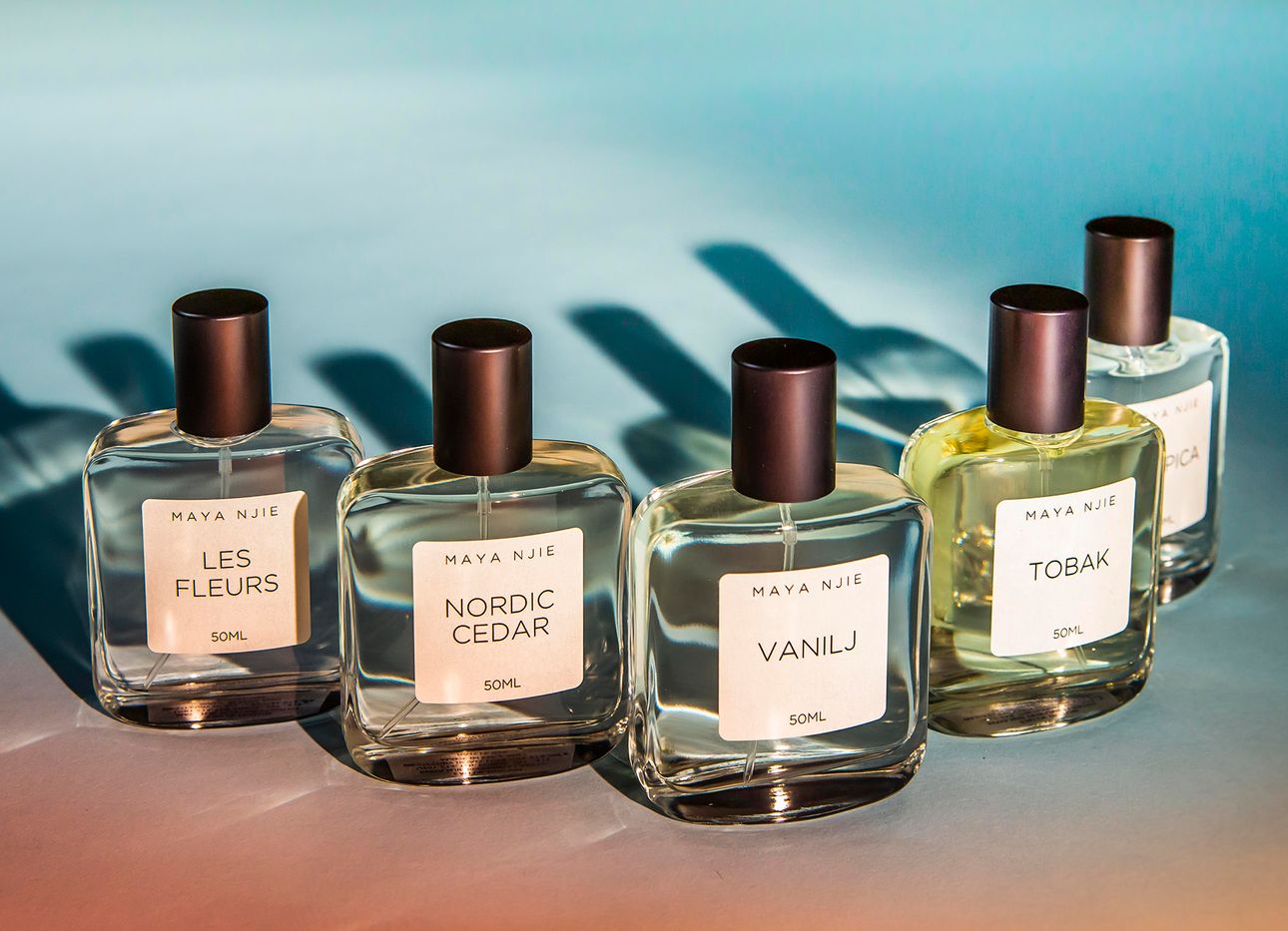 Five bottles of perfume on an ombre table
