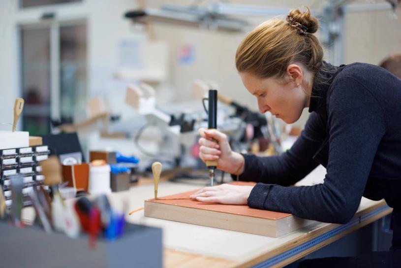 A craftsperson at work inside the leather goods workshop designed by Ghotmeh for Ateliers Hermès. (© Lina Ghotmeh Architecture and Hermès. Photo: Iwan Baan)