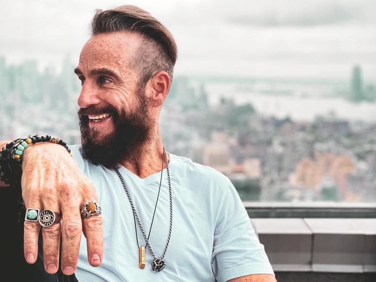 Michel Rojkind smiling and facing to the left, with a blurry background of the New York City skyline.