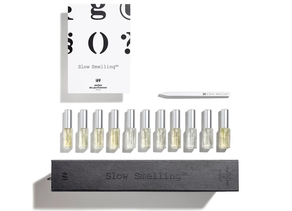 Eleven bottles of perfume with a box and card on a white background.