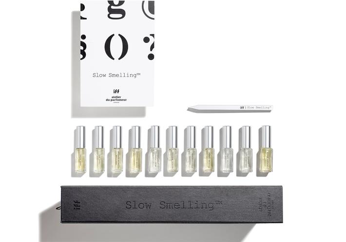 Eleven bottles of perfume with a box and card on a white background.