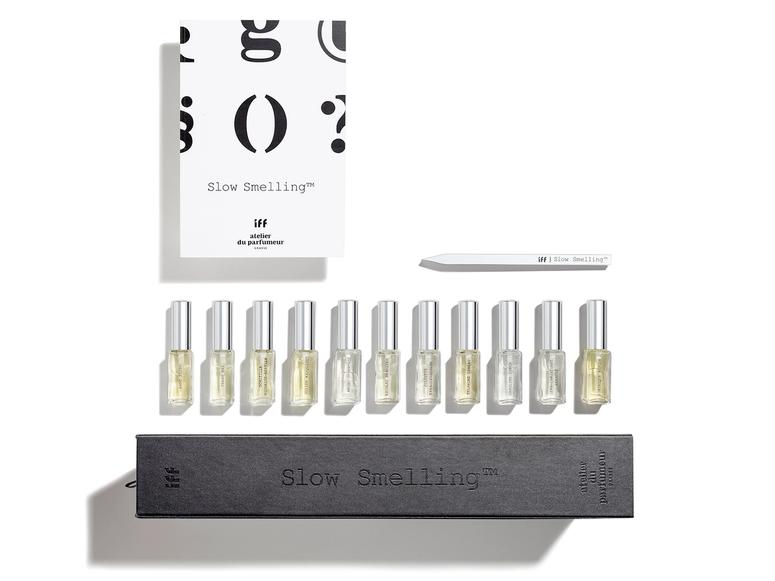 Eleven bottles of perfume with a box and card on a white background.